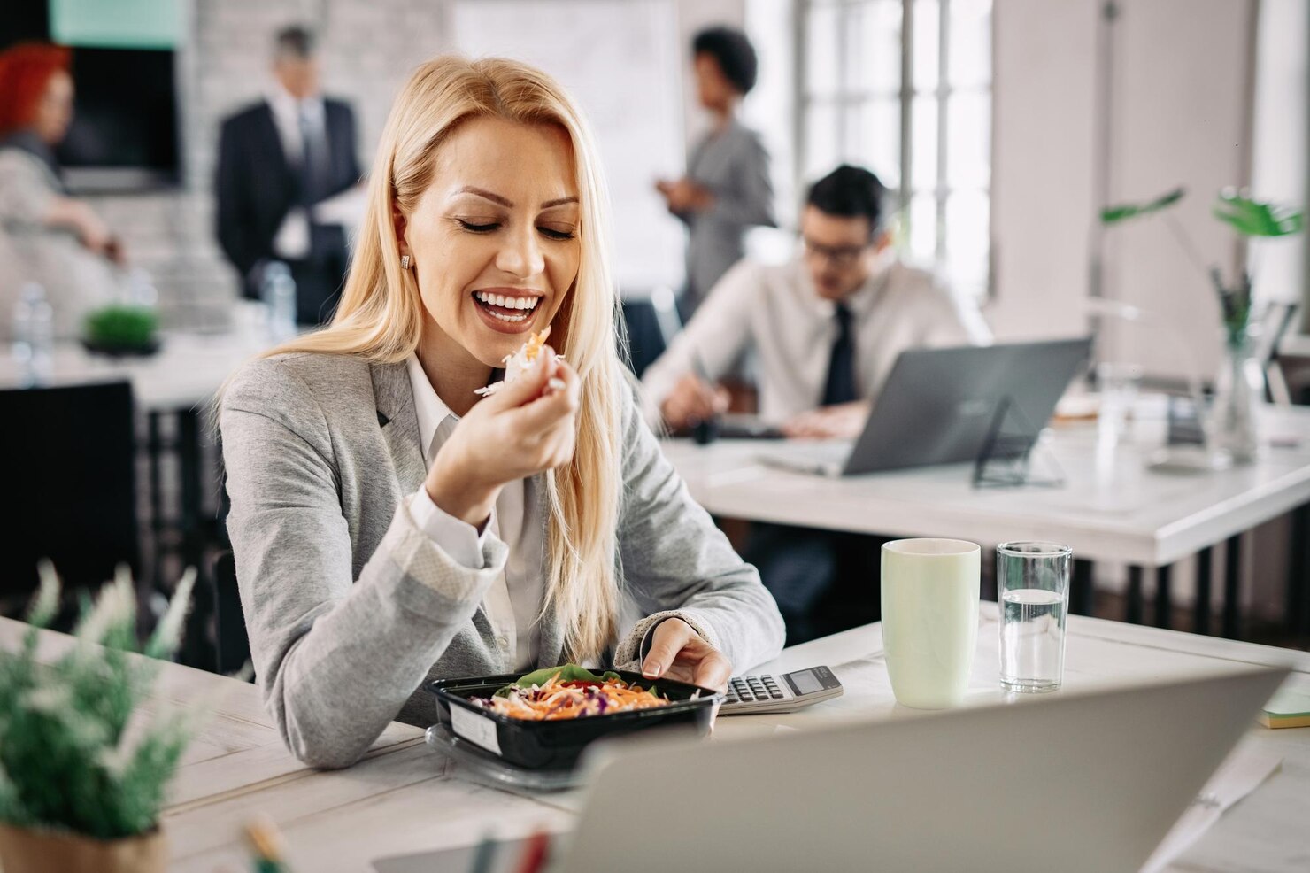 Mulher a comer Mulher a comer uma comida caseira no escritório, depois de receber refeições para empresas